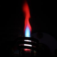 Flamme eines induktiv gekoppelten Plasmas (ICP) mit blauem und rotem Leuchten zur optischen Emissionsspektrometrie in der Metallanalyse
