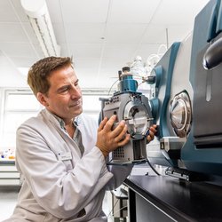 Laborant in weißem Kittel baut eine Labormaschine im Labor für ein Experiment auf